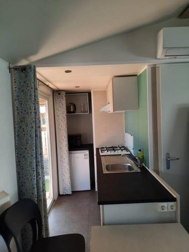 a small kitchen with a sink and a stove at CHALETS MERCURE am Wallersee zum Vermieten in Helming