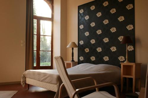 Saint Laurent NouanにあるB&B Le Logis de Bois Renardのベッドルーム1室(ベッド1台、窓際の椅子付)