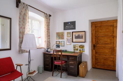 an office with a desk and a red chair and a door at House 1797 - Charm of Slovenian Vintage in Dob