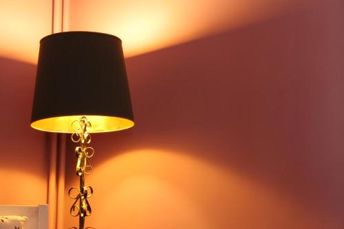 a lamp with a black shade next to a wall at B&B Le Logis de Bois Renard in Saint Laurent Nouan