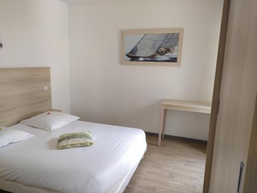 a bedroom with a white bed and a table at Lagrange Apart'Hotel l’Escale Marine in La Rochelle