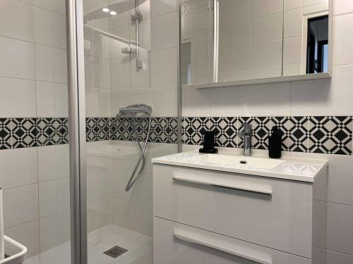 une salle de bain blanche avec un lavabo et une douche dans l'établissement Appartement bord de mer 2 pièces avec parking à Saint-Gilles-Croix-de-Vie - FR-1-224-764, à Saint-Gilles-Croix-de-Vie