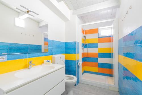 bagno colorato con lavandino e servizi igienici di Casammare a Marina di Modica