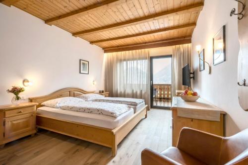 sypialnia z łóżkiem i dużym oknem w obiekcie Pension Appartment Hecherhof w Meranie