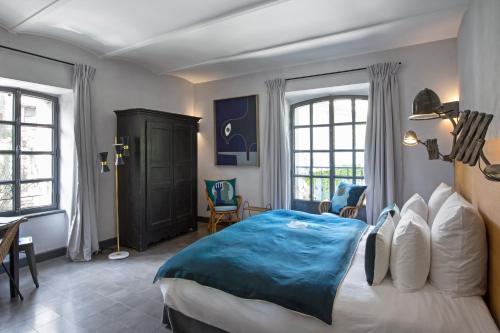 a bedroom with a large bed with a blue blanket at Auberge de Banne in Banne