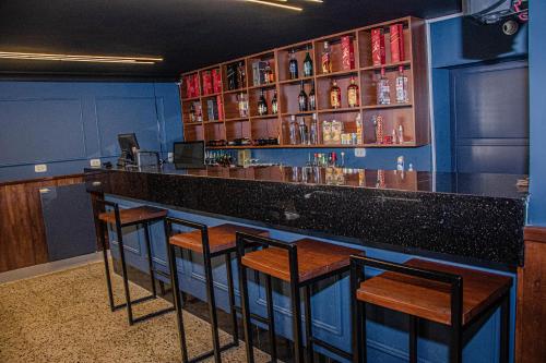 un bar con quattro sgabelli in una stanza di Real Hotel a Huánuco