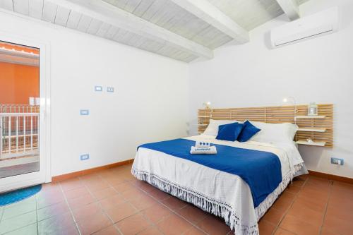 a bedroom with a bed with blue and white pillows at Casammare in Marina di Modica