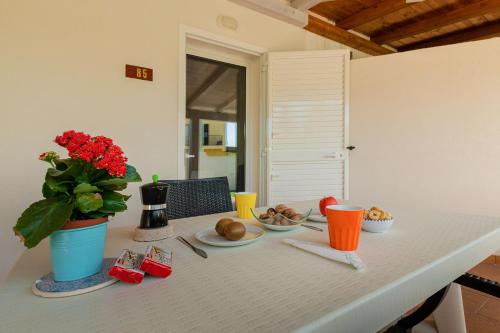 a table with a plate of food and a vase of flowers at Casammare in Marina di Modica