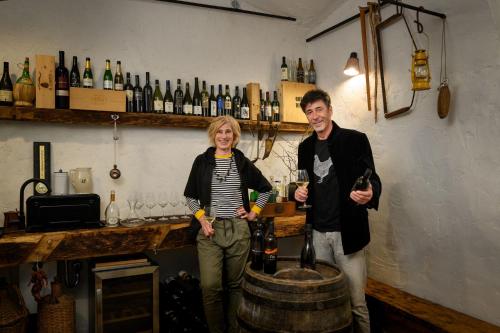 a man and a woman standing next to a barrel of wine at House 1797 - Charm of Slovenian Vintage in Dob