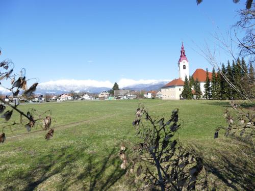 a field with a church in the background with a church tower at House 1797 - Charm of Slovenian Vintage in Dob