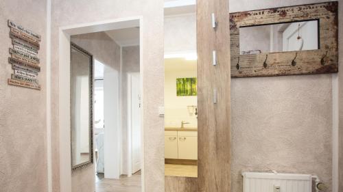 - deux images d'une salle de bains avec un miroir et un couloir dans l'établissement Feriensuite "Kappe Deluxe", à Winterberg