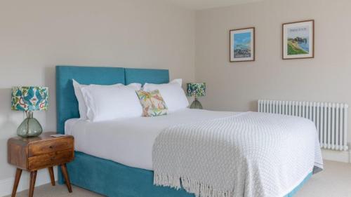 a bedroom with a large bed with a blue headboard at The Bear Hotel in Wareham