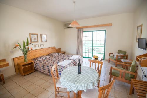 1 dormitorio con 1 cama y 1 mesa con comedor en Eligonia Hotel Apartments, en Ayia Napa