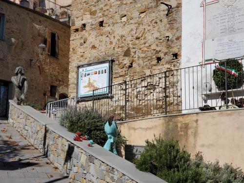a statue of a woman standing next to a stone wall at Casa canadesi in Costarainera