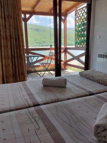a bed in a room with a large window at Vila Jana Mavrovo in Mavrovo