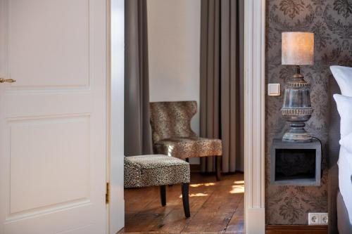 a bedroom with a chair and a desk with a lamp at Schloss Rattey in Schönbeck
