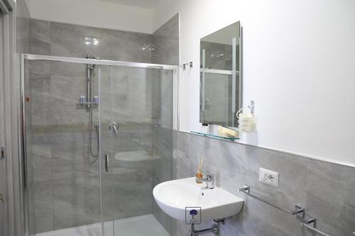 bagno con doccia, lavandino e specchio di Giardino di Edo a Tropea