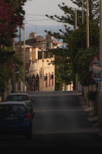 a street with cars parked in front of a building at Casammare in Marina di Modica