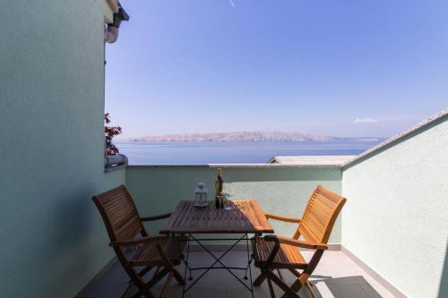 a table and chairs on a balcony with a view of the water at Apartment Žuna in Senj