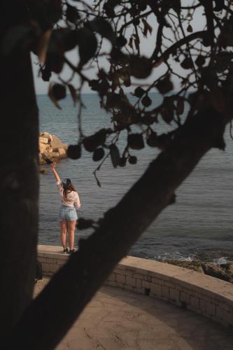 a woman standing on a ledge looking at the water at Casammare in Marina di Modica