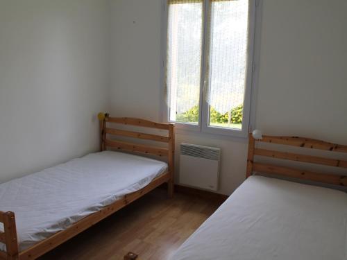 duas camas num pequeno quarto com duas janelas em Maison La Roche-Posay, 3 pièces, 5 personnes - FR-1-541-47 em La Roche-Posay