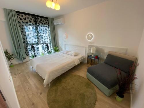 une chambre avec un lit, une chaise et une fenêtre dans l'établissement Green apartments 109-7 with roof top view, à Bucarest