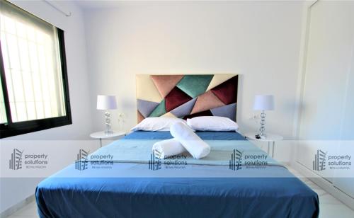 Dormitorio con cama azul y cabecero colorido en Pueblo del parque 12 - Terraza - Piscina y Playa- Urbanización tranquila- Perfecto para descansar, en Benalmádena