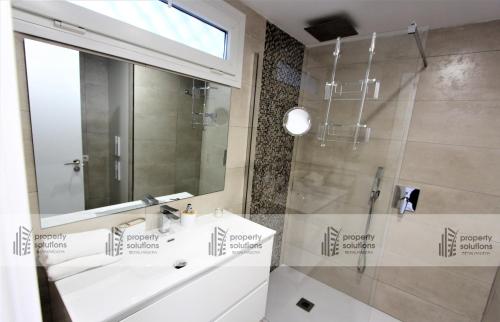 Un baño con ducha, lavabo y espejo. en Pueblo del parque 12 - Terraza - Piscina y Playa- Urbanización tranquila- Perfecto para descansar, en Benalmádena