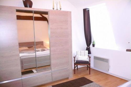 a bedroom with a large glass cabinet with a bed at Chez Lisette Honfleur 500m plage in Honfleur