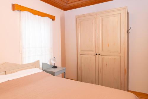 a bedroom with a bed and a closet and a window at Zelinia in Vitsa