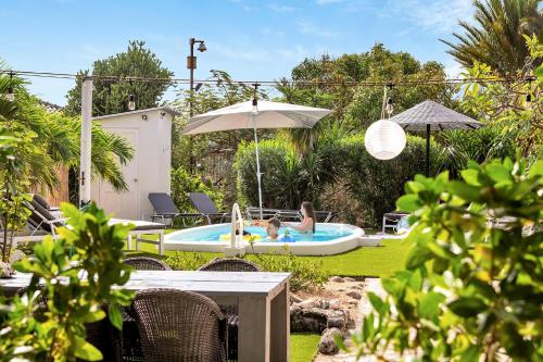 a backyard with a pool with two people in it at Windsock Apartment Caribbean Dream in Kralendijk