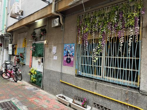 un edificio con una ventana con plantas. en HouseNandoor en Tainan