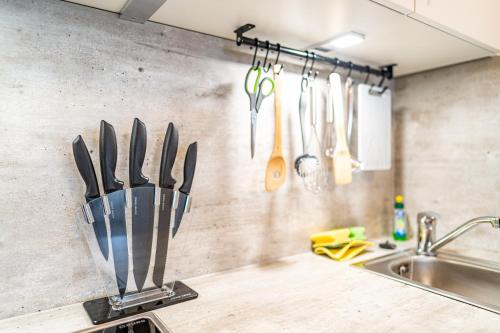 un comptoir de cuisine avec des couteaux suspendus à un mur dans l'établissement TAGBLATT Apartment 2, à Tuttlingen