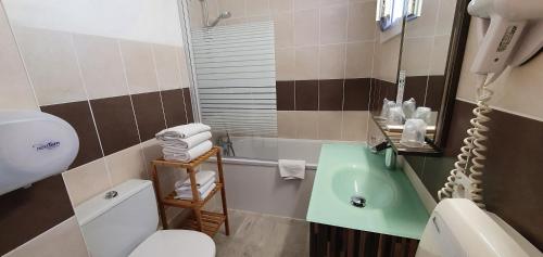 a bathroom with a sink and a toilet and a tub at Hôtel Port Beach in Gruissan