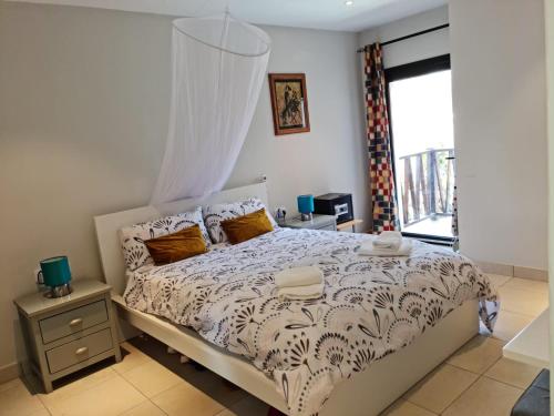a bedroom with a bed and a window at Forest View Apartments in Kololi