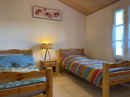 une chambre avec deux lits et une lampe dans l'établissement Maison avec jardin clos et terrasse, proche plage et commerces, 5 couchages, Noirmoutier-en-l'Île - FR-1-224B-83, à Noirmoutier-en-l'lle