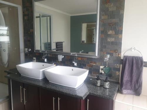 a bathroom with two sinks and a large mirror at 113 Zwartkloof Private Game Reserve Bela-Bela in Bela-Bela