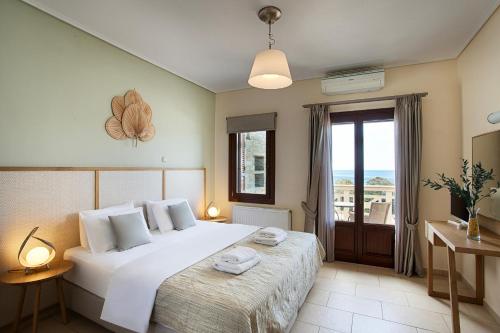 Un dormitorio con una gran cama blanca y una ventana en Aithra -Agios Petros Andros, en Gavrion