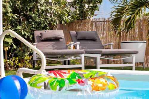 a chair and a table next to a pool at Apartment Delfin at Windsock Beach in Kralendijk