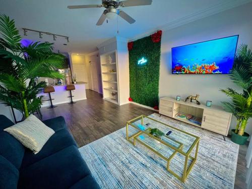 a living room with a blue couch and a tv at Tropical Breeze - 2BR/NRG/Medical Center/Galleria in Houston