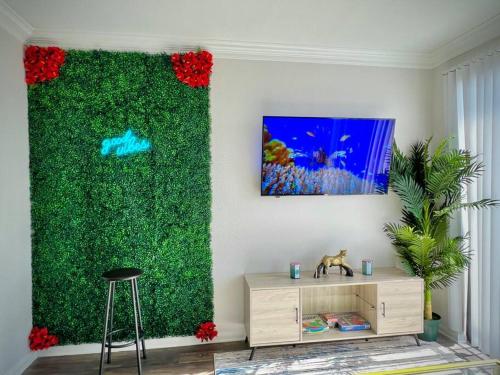 a living room with a green wall with flowers at Tropical Breeze - 2BR/NRG/Medical Center/Galleria in Houston