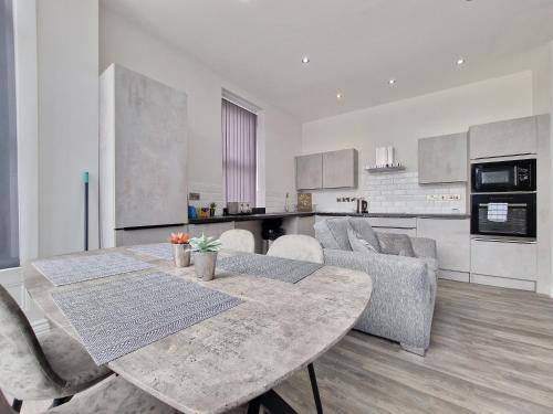 uma cozinha e sala de estar com mesa e cadeiras em DYSA Waterloo Apartments em Blackpool