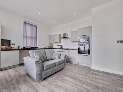 uma sala de estar com um sofá e uma cozinha em DYSA Waterloo Apartments em Blackpool