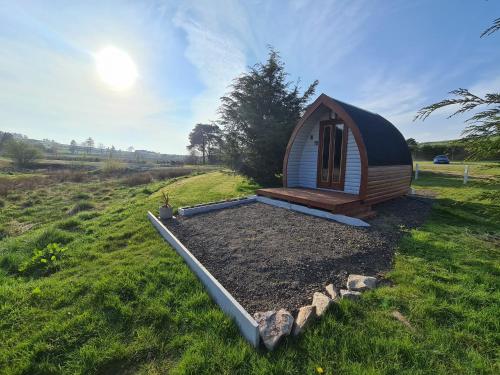 a small cabin in the middle of a field at Delightful Camping Pod in Snowdonia, North Wales. in Derwen