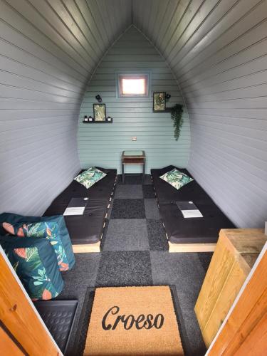a room with three bunk beds in a room at Delightful Camping Pod in Snowdonia, North Wales. in Derwen