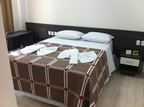 a bedroom with a bed with two towels on it at Di Napoli Plaza Hotel in Gurupi