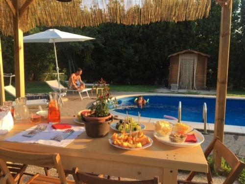 a table with food on it next to a swimming pool at Il Giardino dei Desideri in Viterbo
