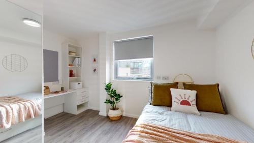 a white bedroom with a bed and a window at Modern and Stylish Studio Apartments at Westcombe House in Greenwich in London