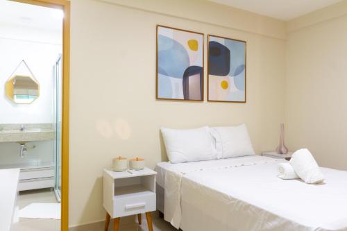 a white bedroom with two beds and a window at Conforto à beira mar! Apartamento com vista para o mar. in Angra dos Reis