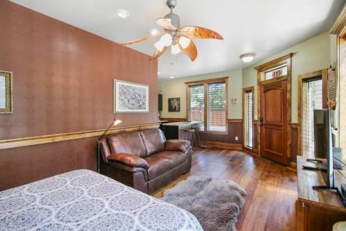 a bedroom with a bed and a couch and a ceiling fan at Safari Cottage in Jacksonville